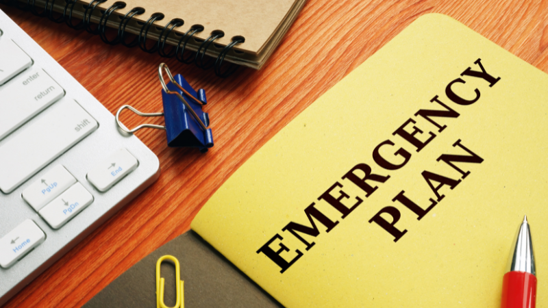 Emergency plan folder on desk surrounded by other items