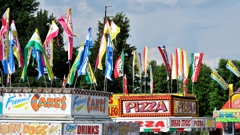 Flags flying on top of food stalls at fair