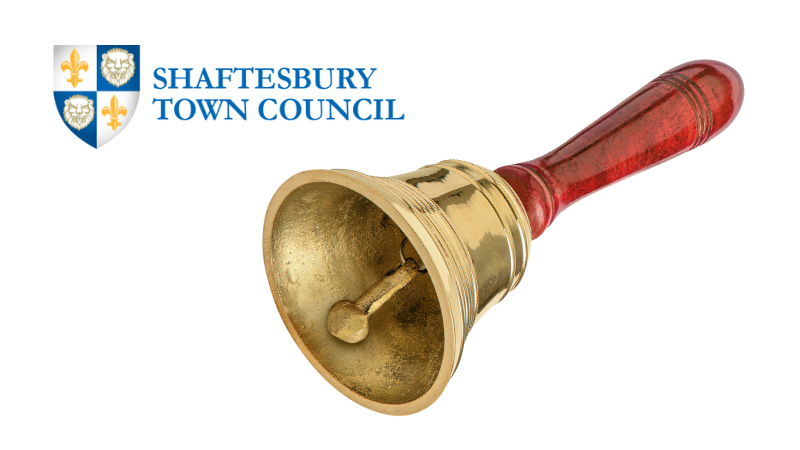 Large brass hand bell with wooden handle. Shaftesbury Town Council logo